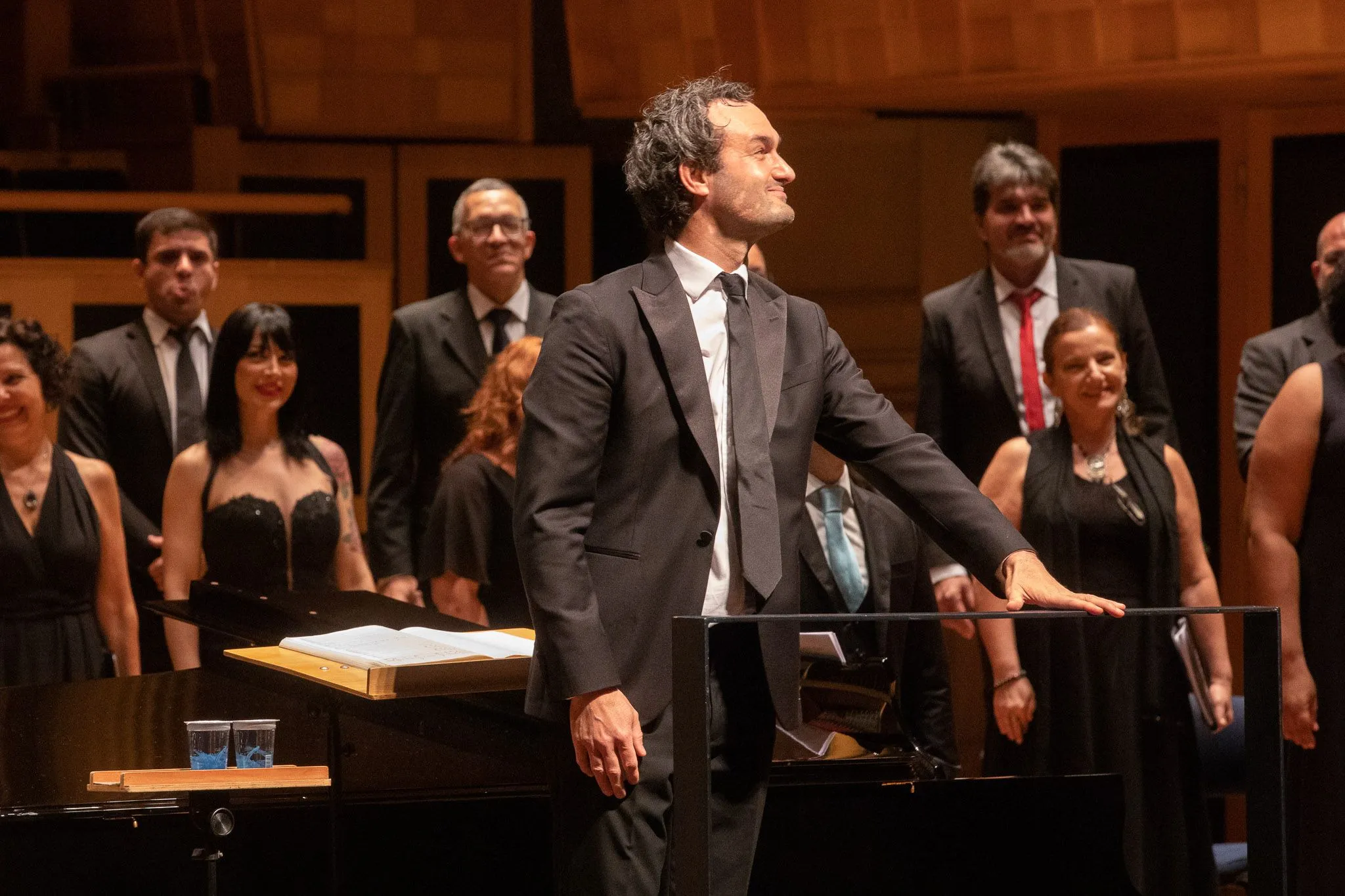 Thomas Blunt é um homem branco, de cabelos castanhos. Ele está no pódio da Sala São Paulo e sorri.