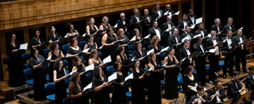 Foto de dezenas de cantores do Coro da Osesp se apresentando no palco da Sala Sao Paulo