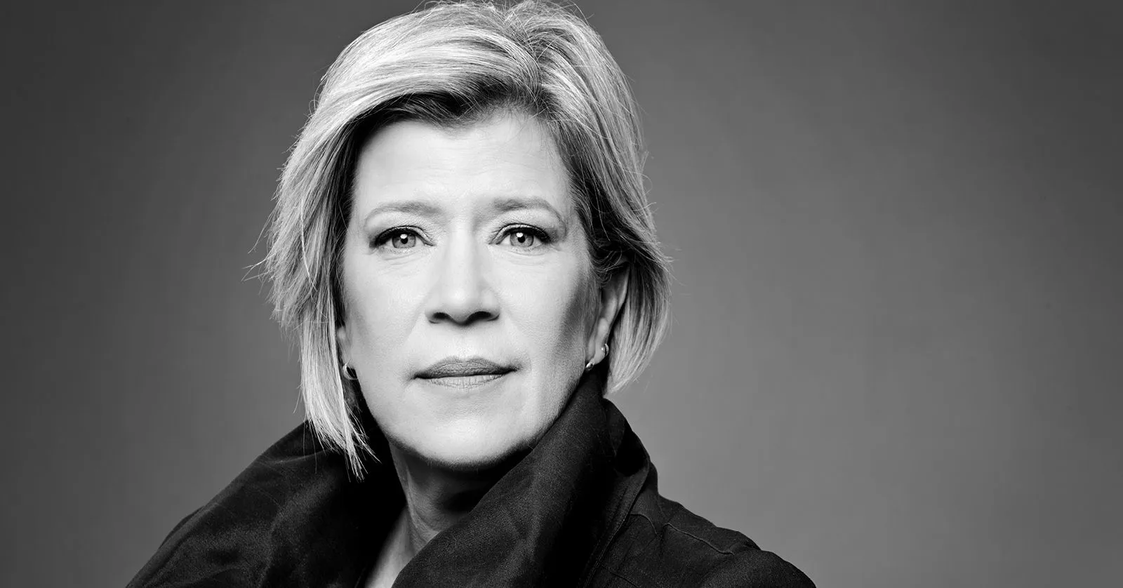 Karen é uma mulher loira, de cabelos curtos.