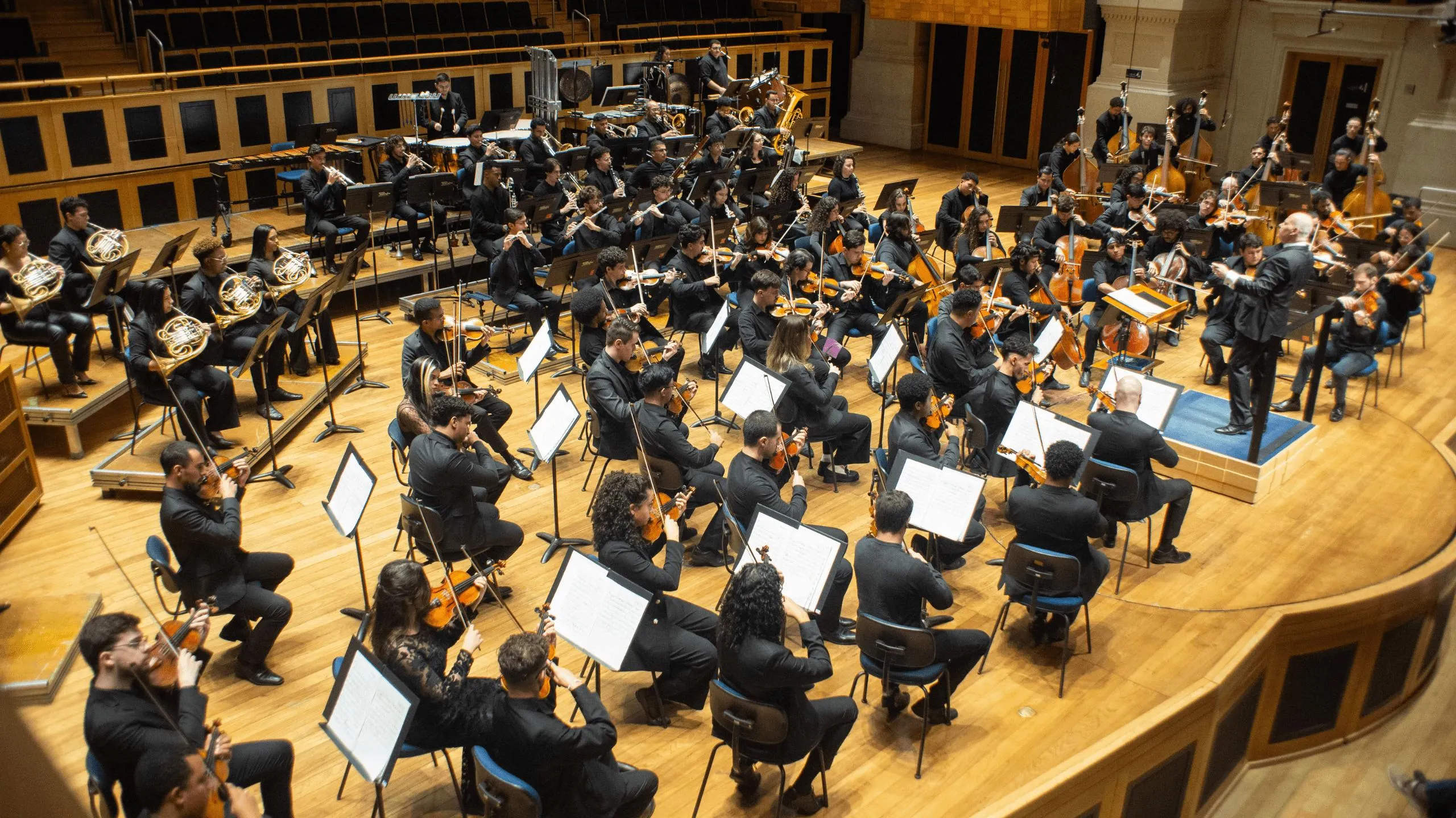 Foto da Orquestra Jovem do Estado tocando no palco da Sala Sao Paulo.