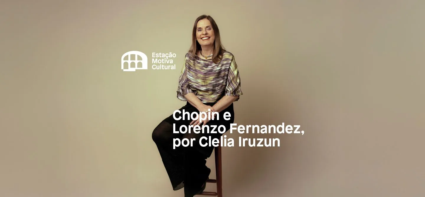 Clélia Iruzun é uma mulher branca e loira, ela está sentada em um banquinho e sorri.