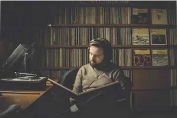 A imagem mostra a Daniil Trifonov, um homem branco de cabelos castanhos, sentado em sua mesa.