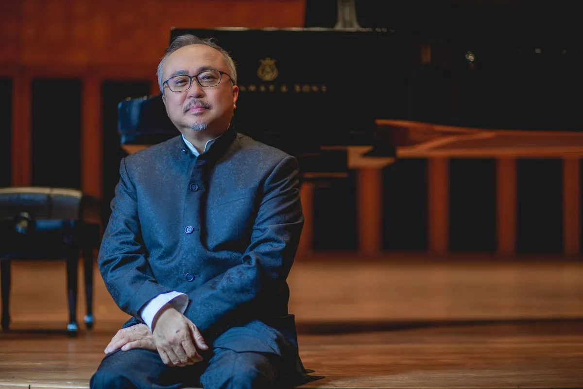 Dang Thai Son é um senhor vietnamita-canadense de cabelos, bigode e barba grisalha. Está sentado a frente de um piano