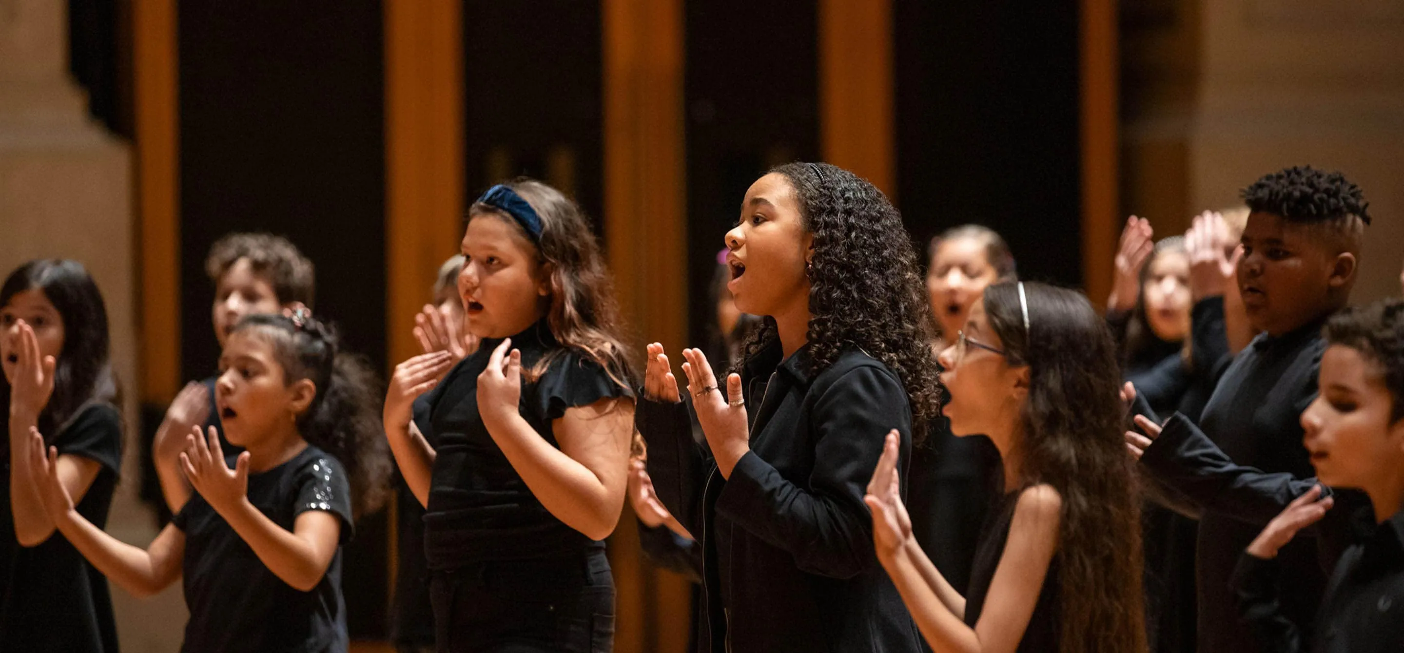 Foto de crianças do Coro Infantil da Osesp cantando.