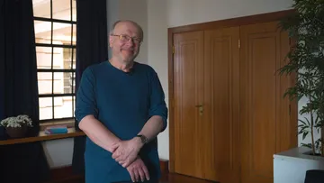 Marc-André Hamelin é um homem branco, calvo e de barba. Ele sorri e usa roupa preta.