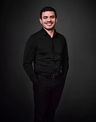 Aldo Duarte é um homem branco, adulto, de cabelo preto curto. Ele está usando uma camisa preta.